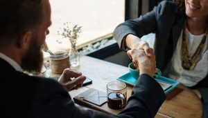 Dos profesionales cerrando un acuerdo con un apretón de manos, representando las alianzas estratégicas que fortalecen nuestra red de servicios de salud.